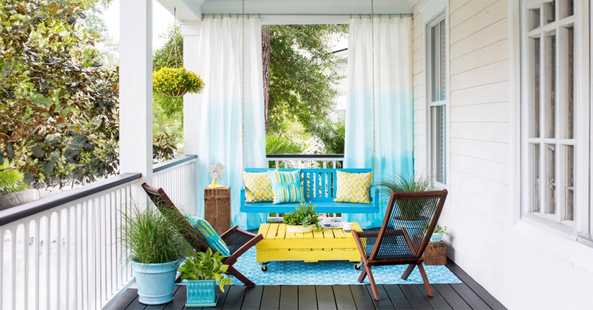 Hanging curtains on porch featuring a porch swing from HGTV.